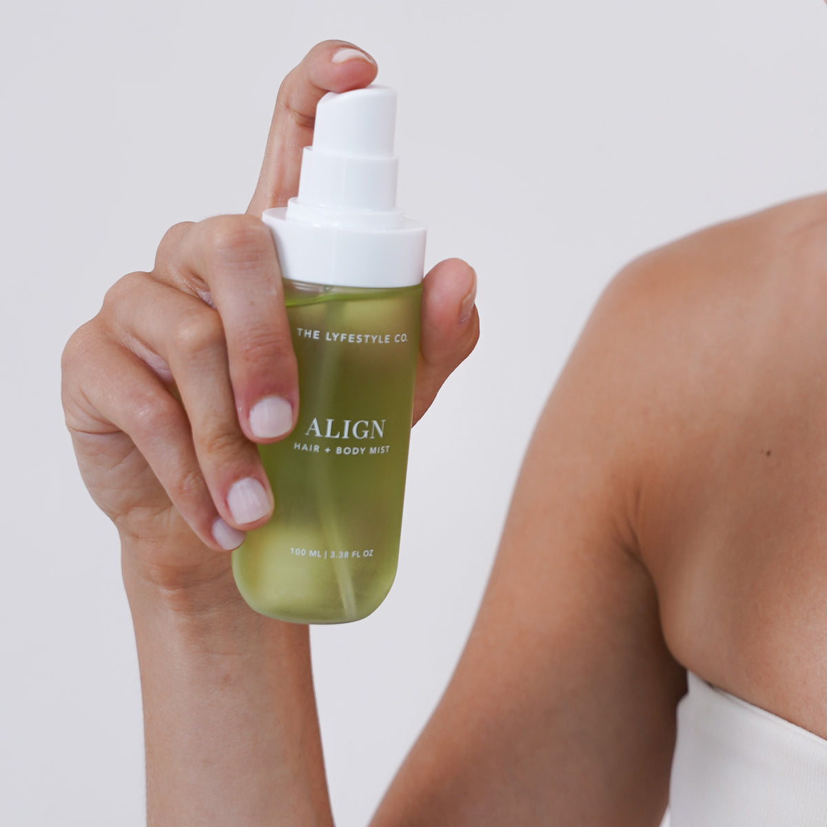 Close-up of The Lyfestyle Co. Align Hair & Body Mist bottle held in one hand.