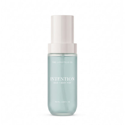 A bottle of The Lyfestyle Co. Intention Hair & Body Mist, featuring a frosted plastic bottle filled with a light blue liquid and a white spray dispenser, set against a plain white background.