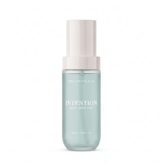 A bottle of The Lyfestyle Co. Intention Hair & Body Mist, featuring a frosted plastic bottle filled with a light blue liquid and a white spray dispenser, set against a plain white background.