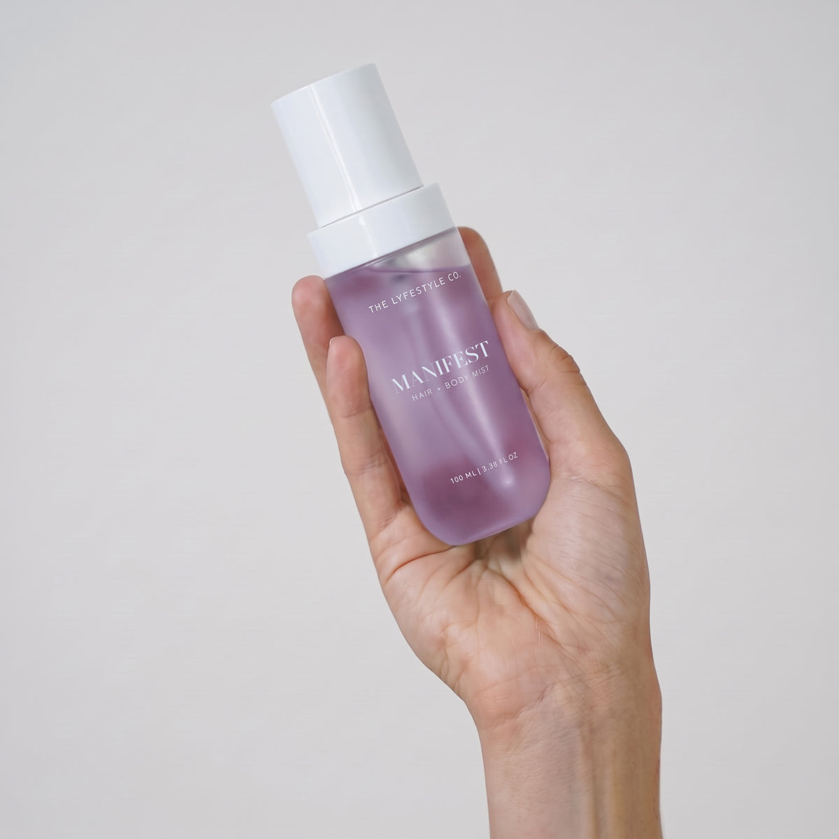 Close-up of The Lyfestyle Co. Manifest Hair & Body Mist bottle held in one hand.