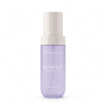 A bottle of The Lyfestyle Co. Manifest Hair & Body Mist, featuring a frosted plastic bottle filled with a lavender liquid and a white spray dispenser, set against a plain white background.