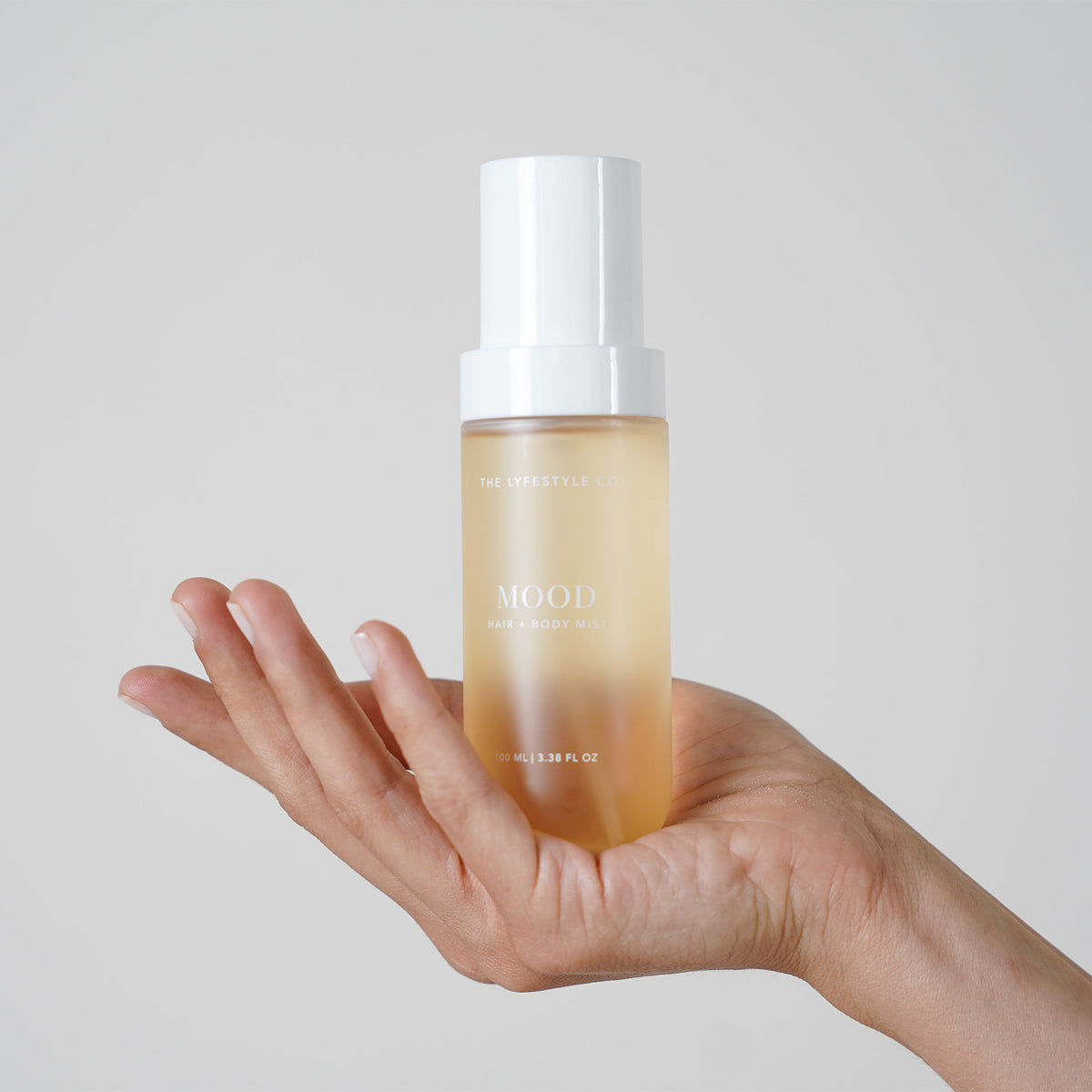 Close-up of The Lyfestyle Co. Mood Hair & Body Mist bottle held in one hand.