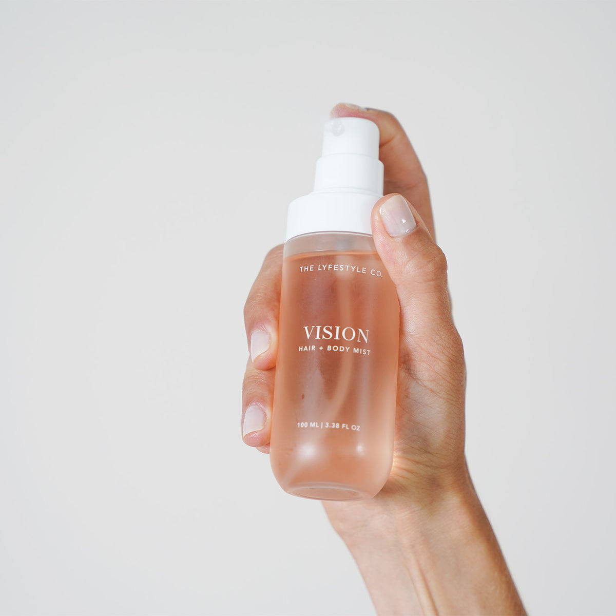 Close-up of The Lyfestyle Co. Vision Hair & Body Mist bottle held in one hand.
