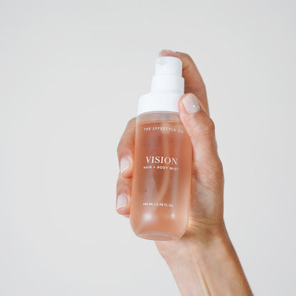 Close-up of The Lyfestyle Co. Vision Hair & Body Mist bottle held in one hand.